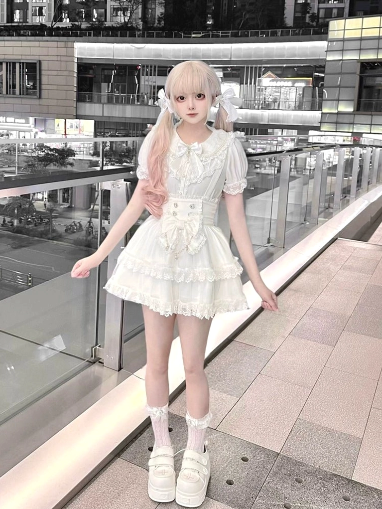 White sweet lolita blouse and suspender skirt set full-body front view with twin-tailed model wearing puffed sleeves, lace trim details, and high-waisted corset waist construction