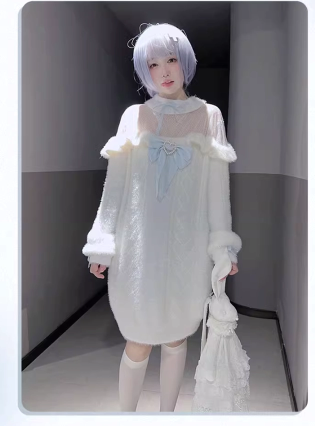 Full-body front standing view of white off-shoulder fuzzy sweater dress in indoor corridor with sheer neck panel and lace handbag