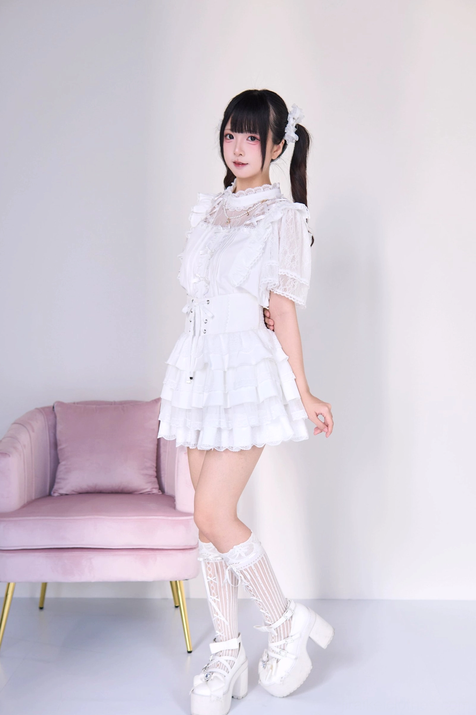 White jirai kei tiered cake skirt with ruffled blouse, side profile full-body view showing puffed lace sleeves layered ruffle mini skirt and white knee-high stockings