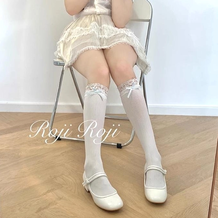 White knee-high Jirai Kei socks with lace trim and satin bow detail complete Lolita outfit aesthetic