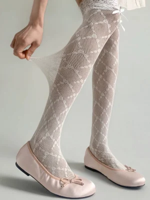 White elastic lace knee-high socks side three-quarter view showcasing stretchy fabric and diamond fishnet pattern with tiny white bow on lace top trim