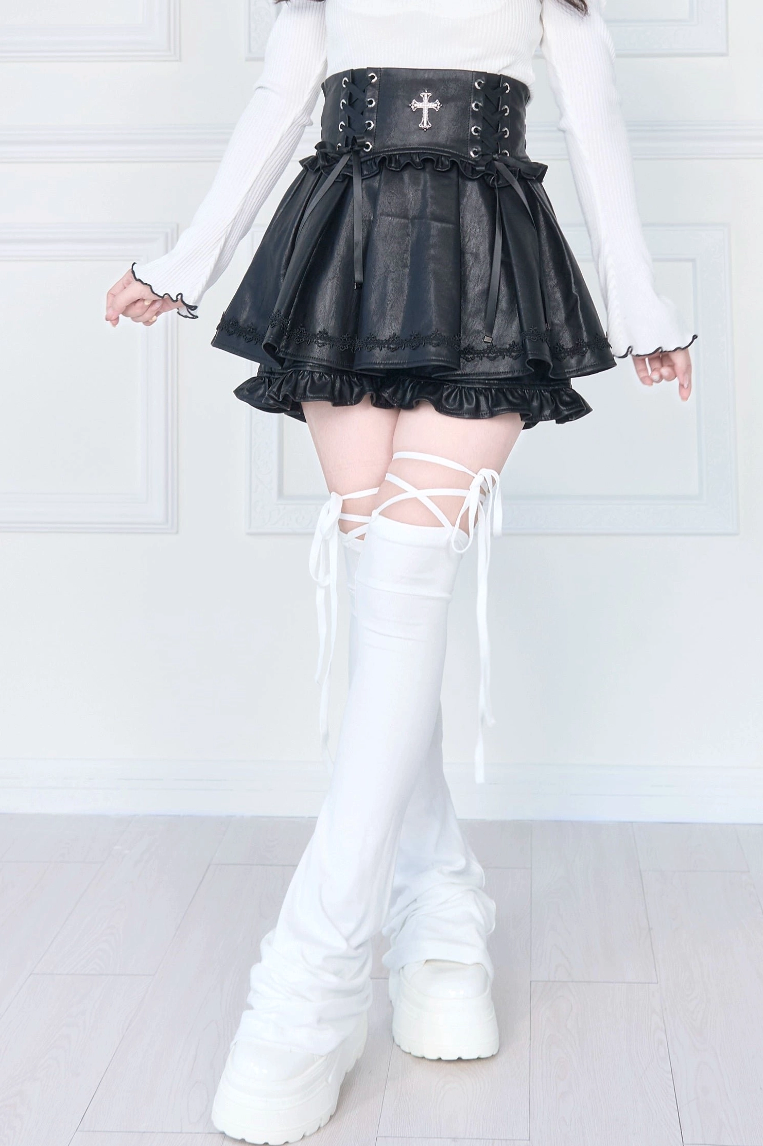 White lace-up thigh-high leg warmers low three-quarter side view with slouchy flared leg design crisscross lace straps and platform loafers