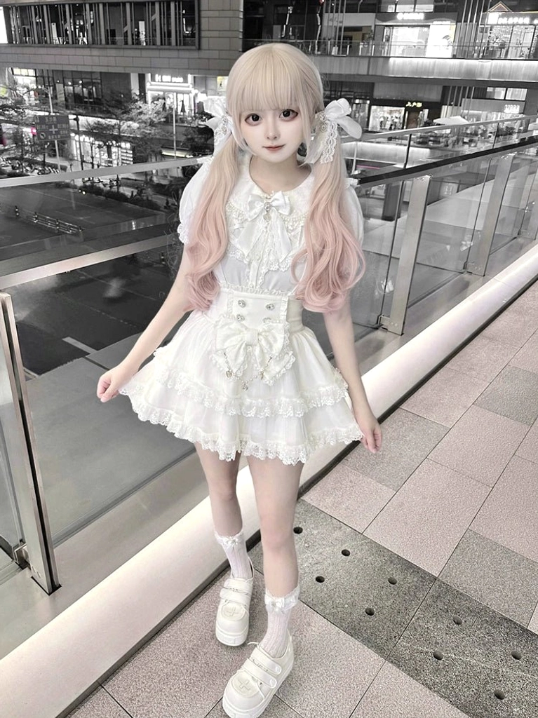 White sweet lolita dress with Peter Pan bow collar and tiered lace skirt hem on outdoor shopping mall balcony, side full-body view of Ryousangata ensemble