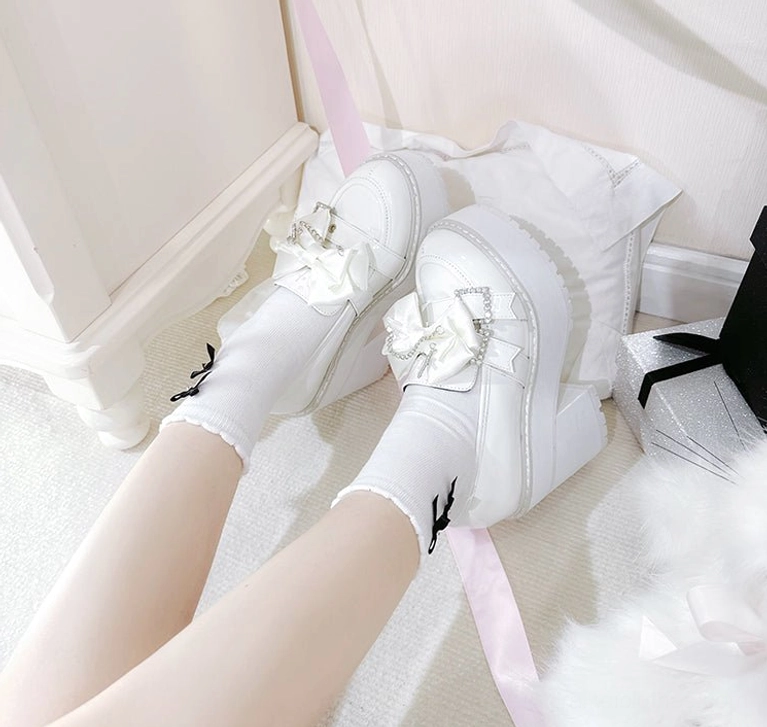 White patent leather Jirai Kei platform shoes full product display showing detachable bow ornament, glossy leather finish, square platform heel design, and complete pair ready for purchase