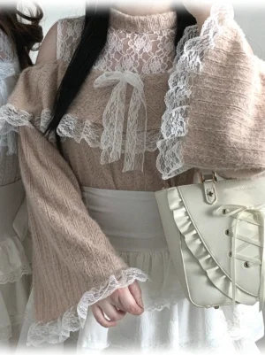White Pink Jirai Kei cold-shoulder lace sweater close-up detail view showing beige fuzzy fabric and ruffled lace frills on neckline with satin bow decoration