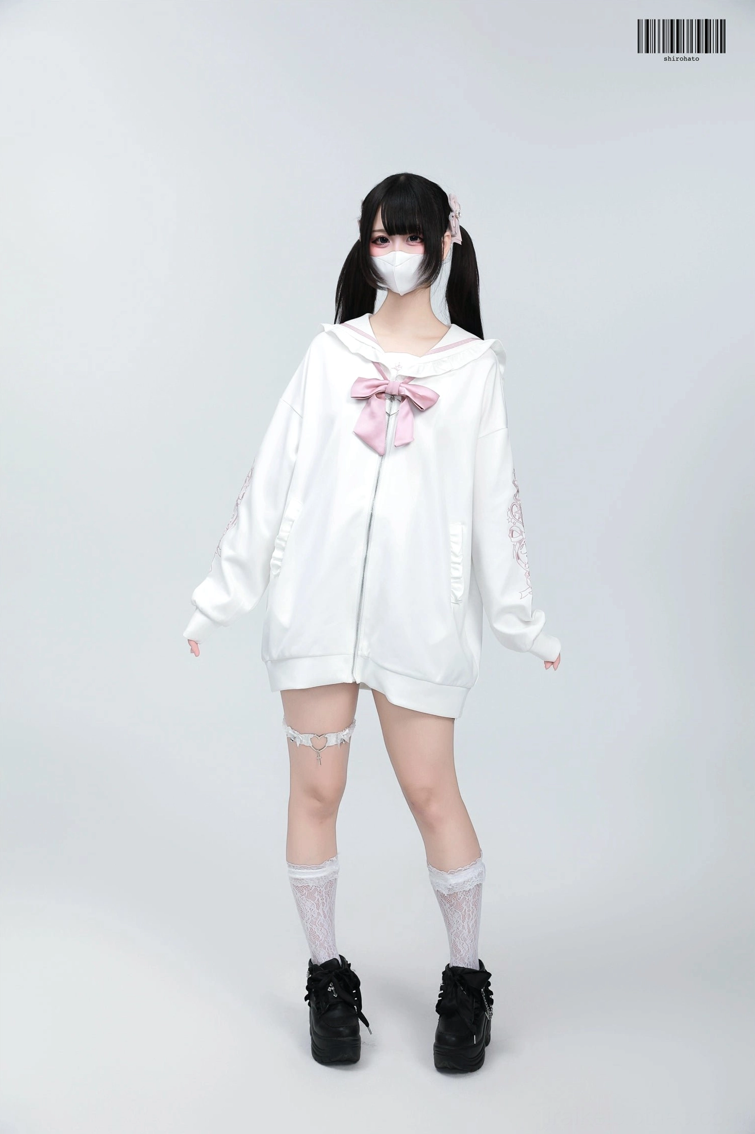 White Jirai Kei sailor jacket with pink bow detailing and embroidery, twin black-haired model wearing platform shoes studio setting