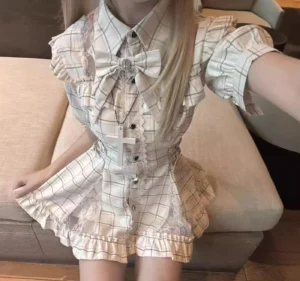 White plaid jirai kei dress set mid-body selfie with checkered pattern bow tie ruffled cuffs and cross pendant accessory detail