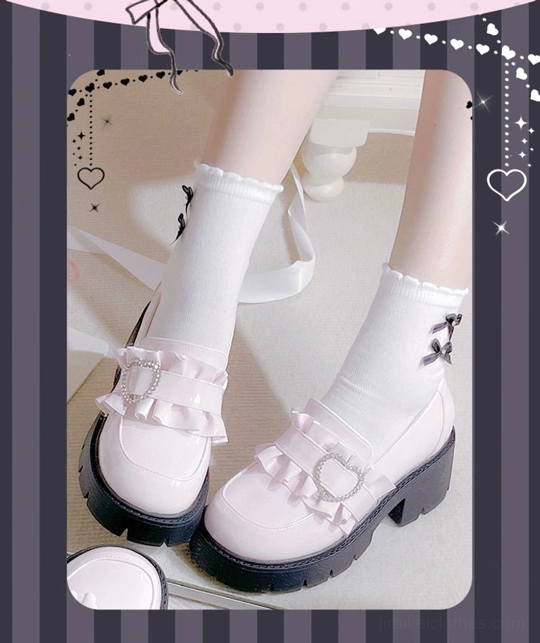 White platform loafers Jirai Kei style with ruffled trim and heart-shaped rhinestone buckle decoration on striped heart-framed background close-up shot