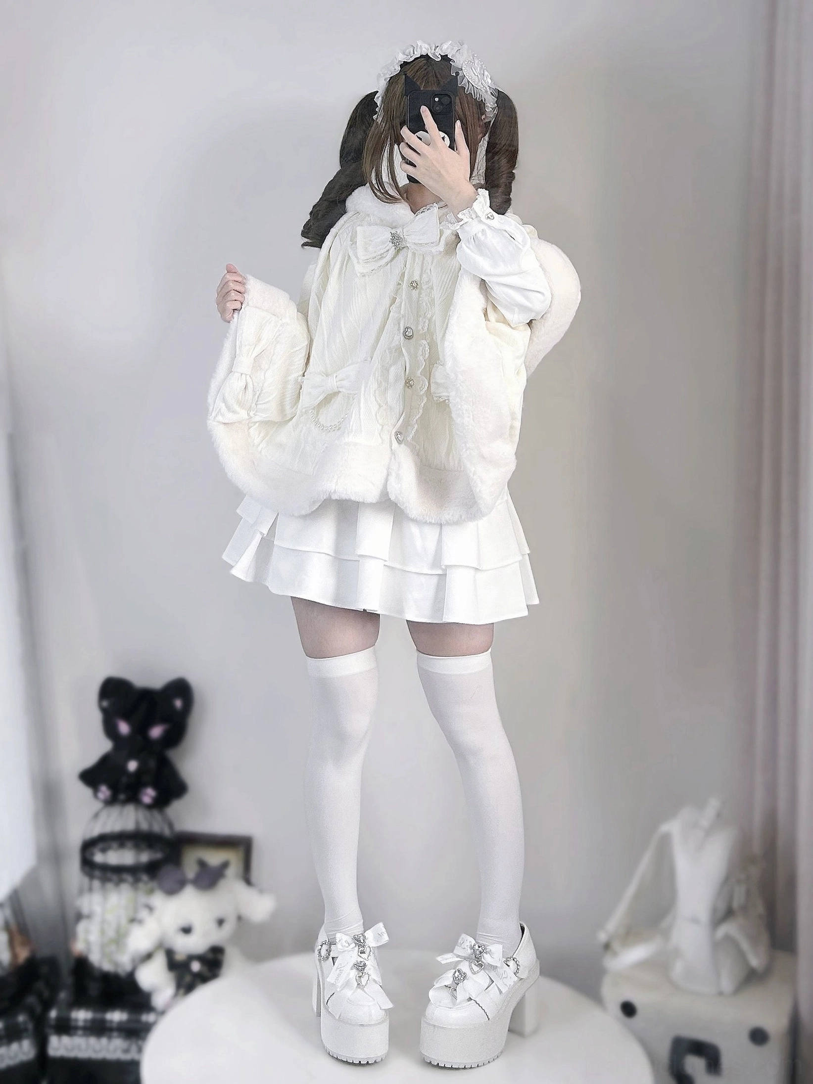 Front view of white rabbit ear fleece hooded cape coat worn by female model in studio, showcasing solid white plush fabric and front button closure with oversized loose fit