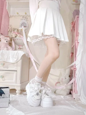 White platform sneakers with subtle pink accents and thick white sole worn with white ruffled skirt and white lace ankle socks Jirai Kei fashion