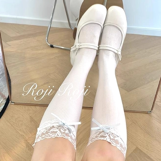 White ribbed knee-high Jirai Kei socks with lace bow cuff top-down view paired with white Mary Janes