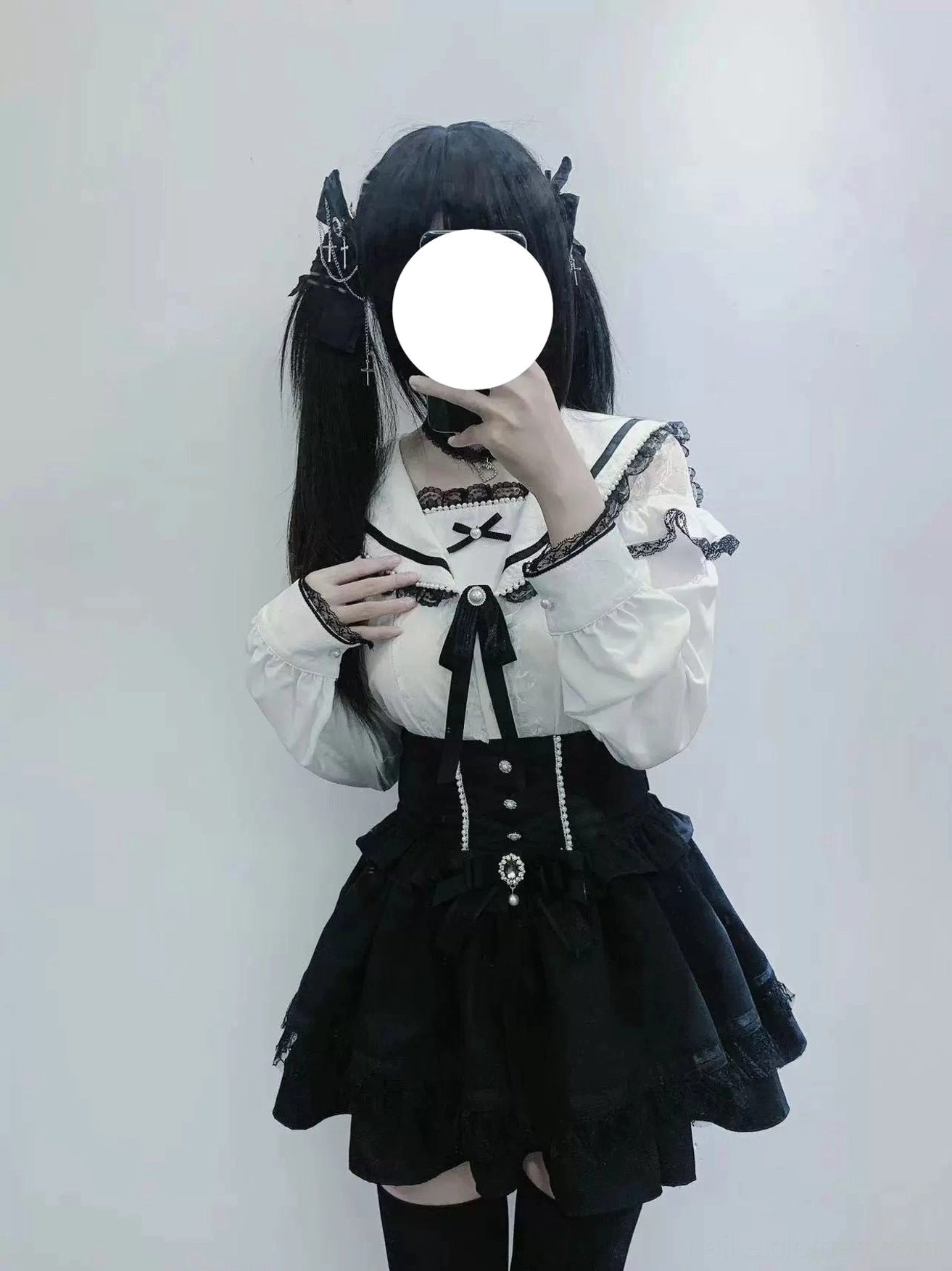 Studio chest-up portrait of faceless female model wearing white Jirai Kei sailor collar blouse featuring lace-trimmed neckline, removable black bow accent, and detailed ruffled sleeve cuffs with pearl buttons
