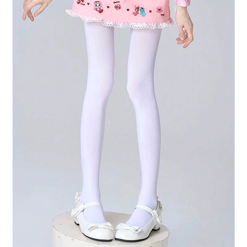 Solid white seamless opaque sheer pantyhose full lower body view on model wearing pink frilled skirt and white Mary Jane shoes plain studio background clean minimalist style