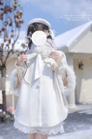 Front upper-body close-up of white wool blend Jirai Kei cloak with faux fur cuffs and beige blouse, featuring hand-tied bow necktie and ruffled hem details
