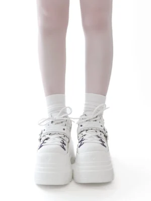 White Y2K jirai kei chunky platform shoes with purple eyelet details, front view on female model wearing white socks, plain background