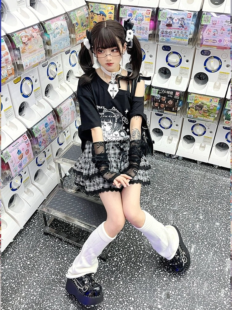Sitting pose Y2K anime skirt set with black off-shoulder graphic tee and black-white plaid skirt, worn with knee-high white socks and platform shoes