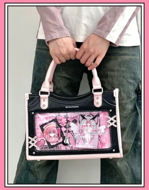 Black and pink dual-tone Y2K Jirai Kei ita bag held by male model, front view displaying clear anime character window with top leather handles and casual streetwear styling