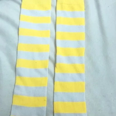 Yellow and white striped over-the-knee socks flat lay, Y2K nostalgia bright colorway horizontal stripe pattern